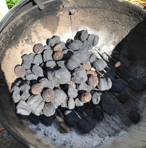 image of a grill full of both charcoal and walnuts